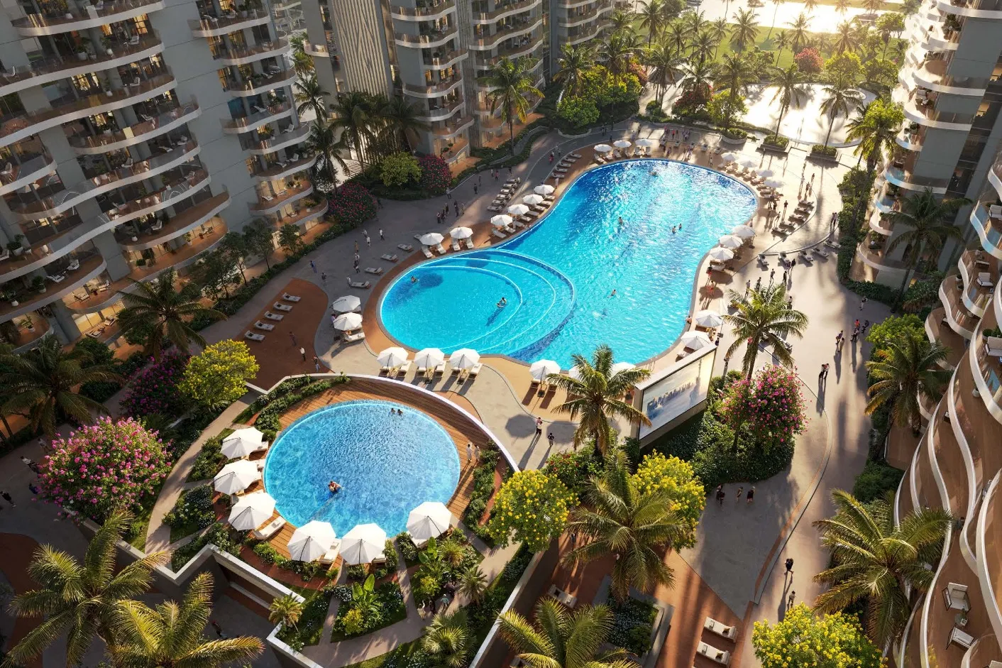 Aerial of curved swimming pools edged with palms and sun loungers